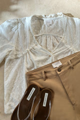 white embroidered top and brown pants top view
