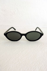 Black sunglasses on a textured white surface
