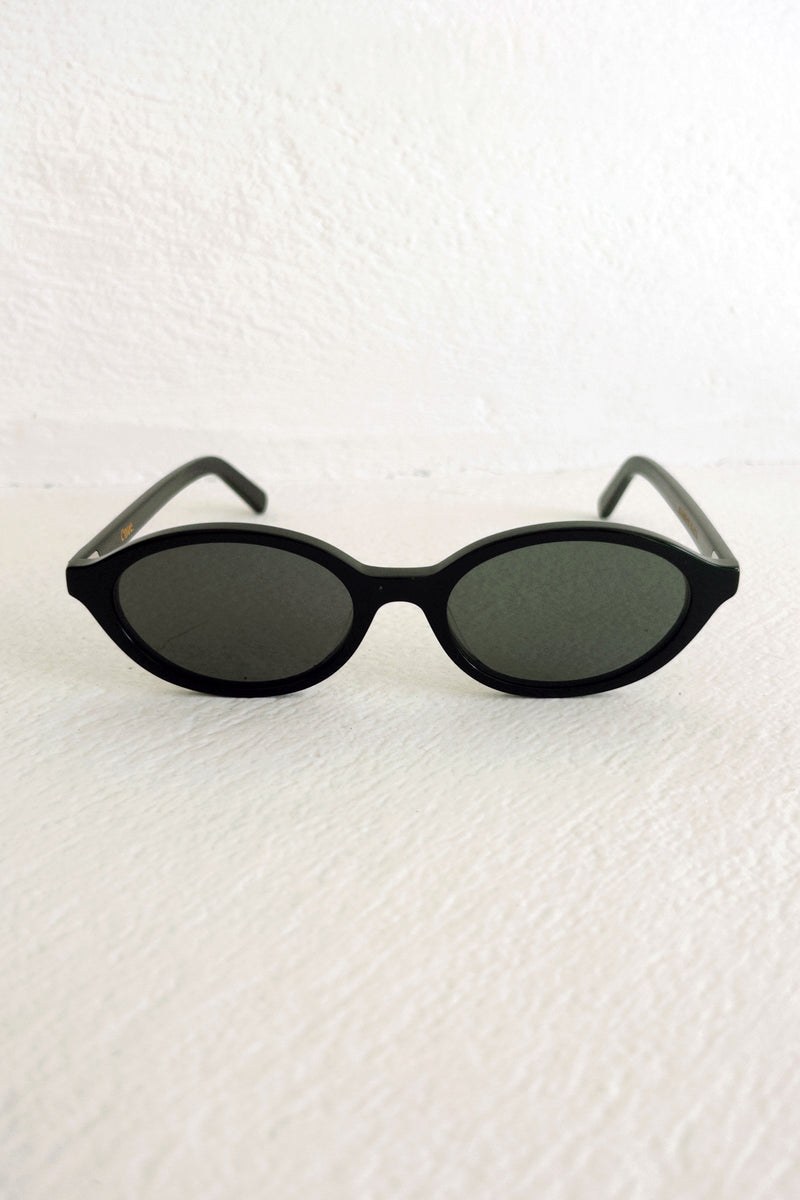 Black sunglasses on a textured white surface