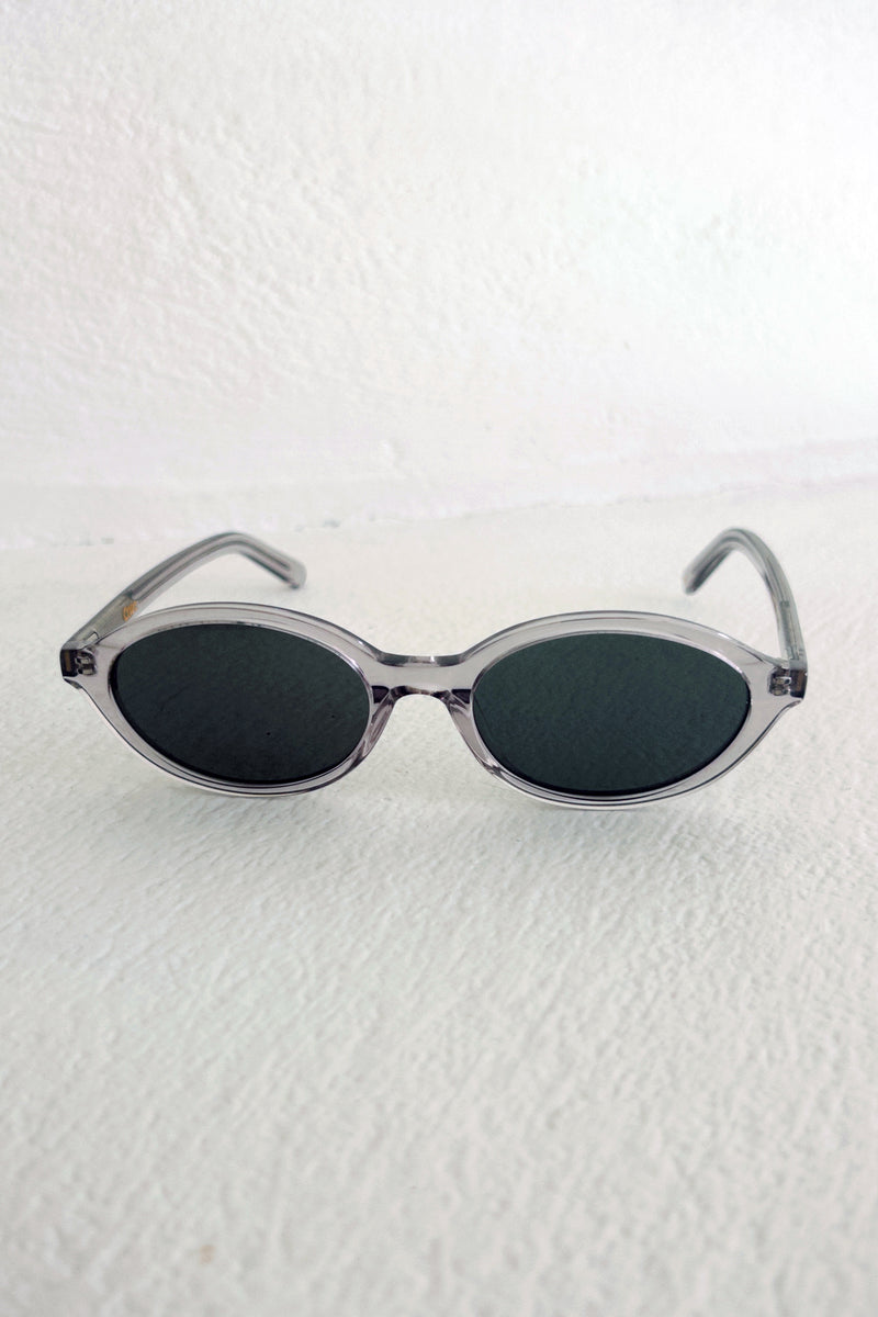 Sunglasses with oval lenses and clear frame on a white background