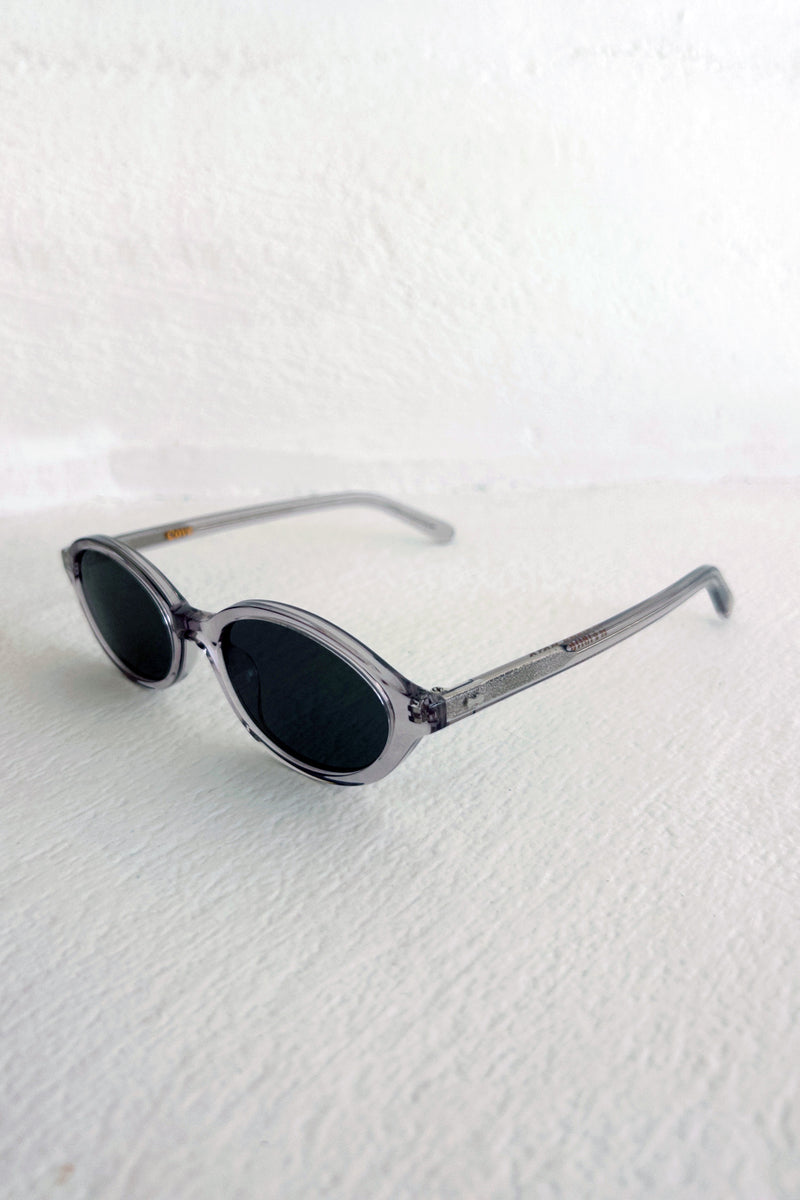 Sunglasses with oval lenses on a textured white surface