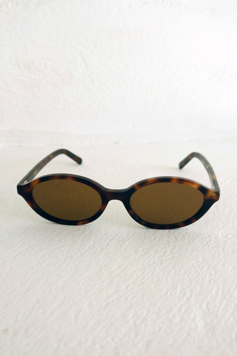 Sunglasses with tortoiseshell frame and brown lenses on a white background