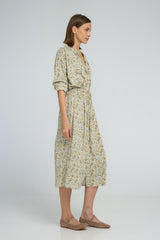 Side profile of floral shirt dress featuring rolled sleeves and elastic waist shaping