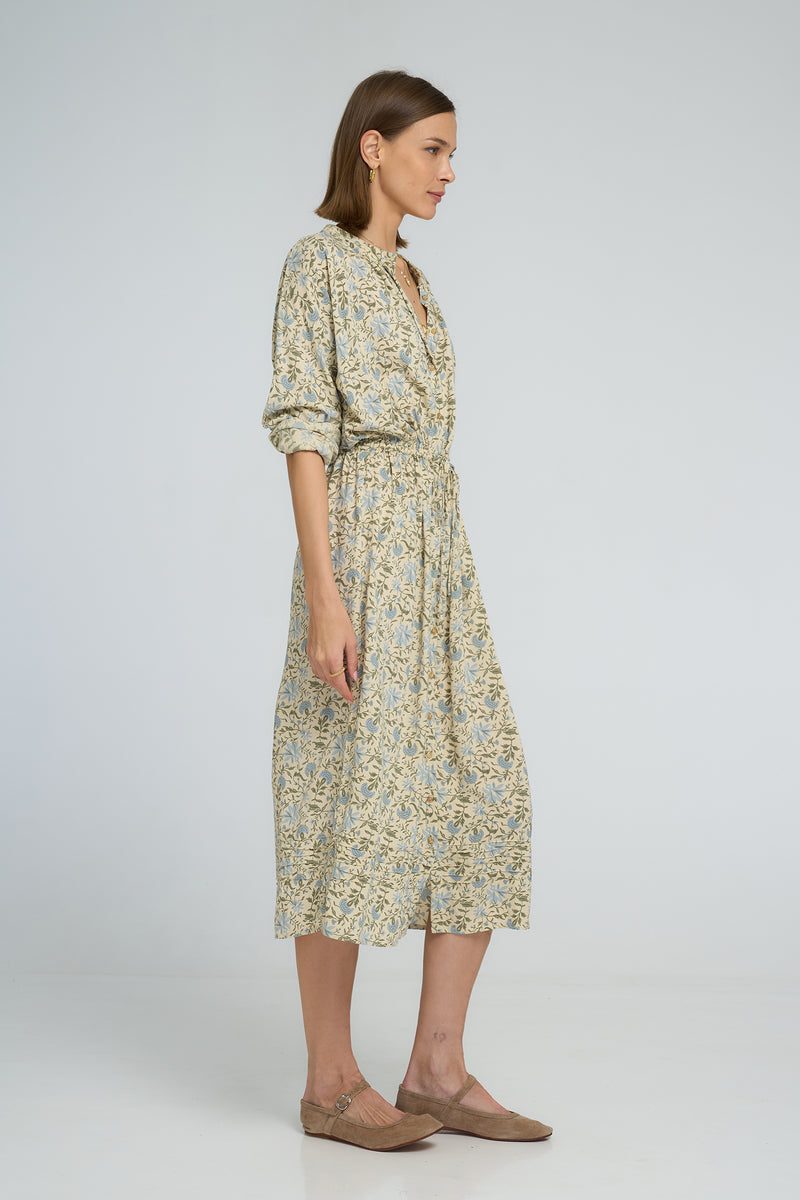 Side profile of floral shirt dress featuring rolled sleeves and elastic waist shaping