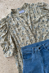 A flatlay image of the Woodford Blouse floral print by Lilya