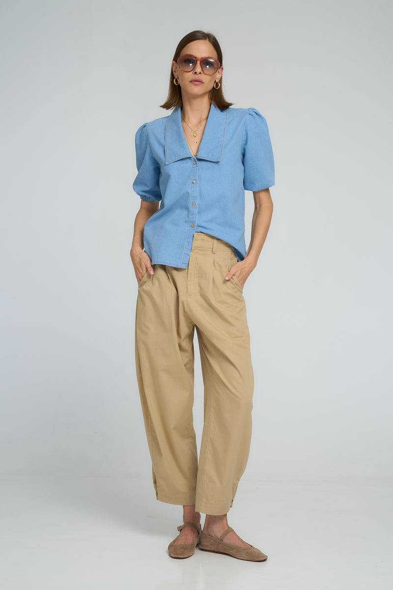 Model wearing a light blue fashionable chambray blouse
