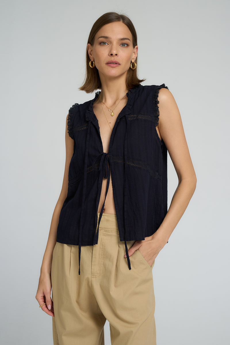 Sleeveless navy cotton lace top styled casually with relaxed utility pants
