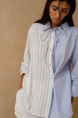 Blue striped shirt featuring unique side button detail 