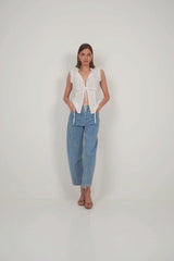 White sleeveless lace-trimmed cotton top paired with pale denim for effortless summer style