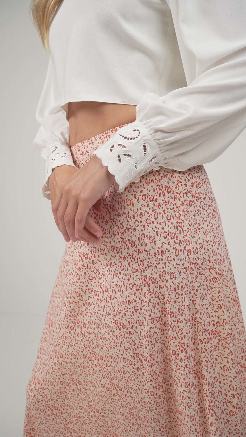 A model wearing a white and orange floral skirt
