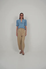 A model wearing a modern light blue chambray top