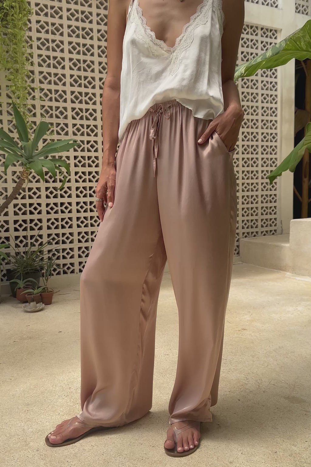 a woman wearing white lace top and silky pants