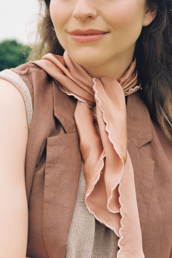 Woman wearing a pink scarf with brown vest