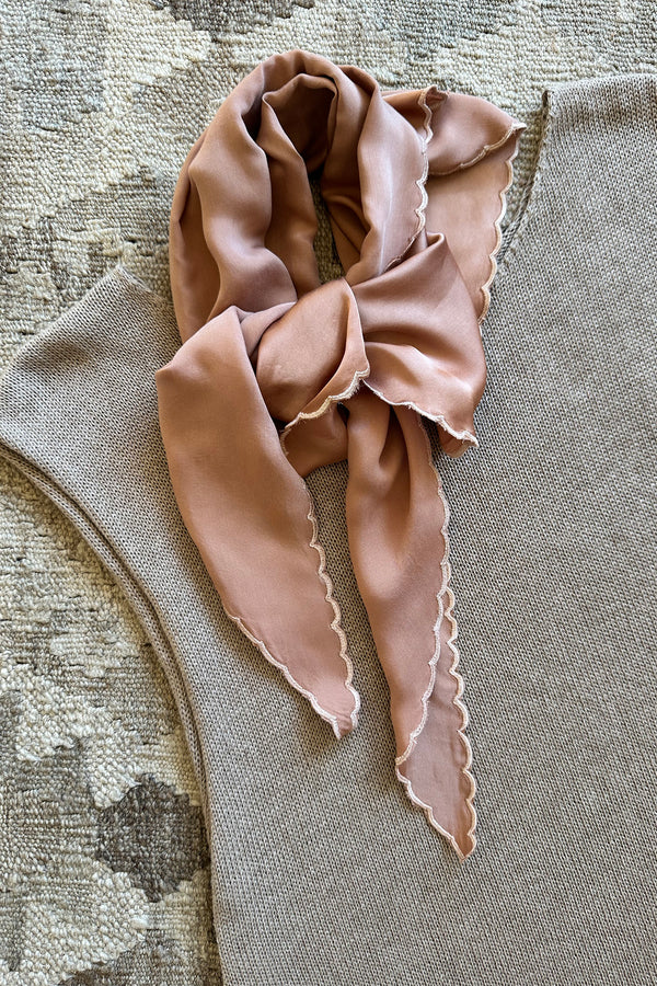 Rose bisque scarf with ruffled edges on sleeveless knit top