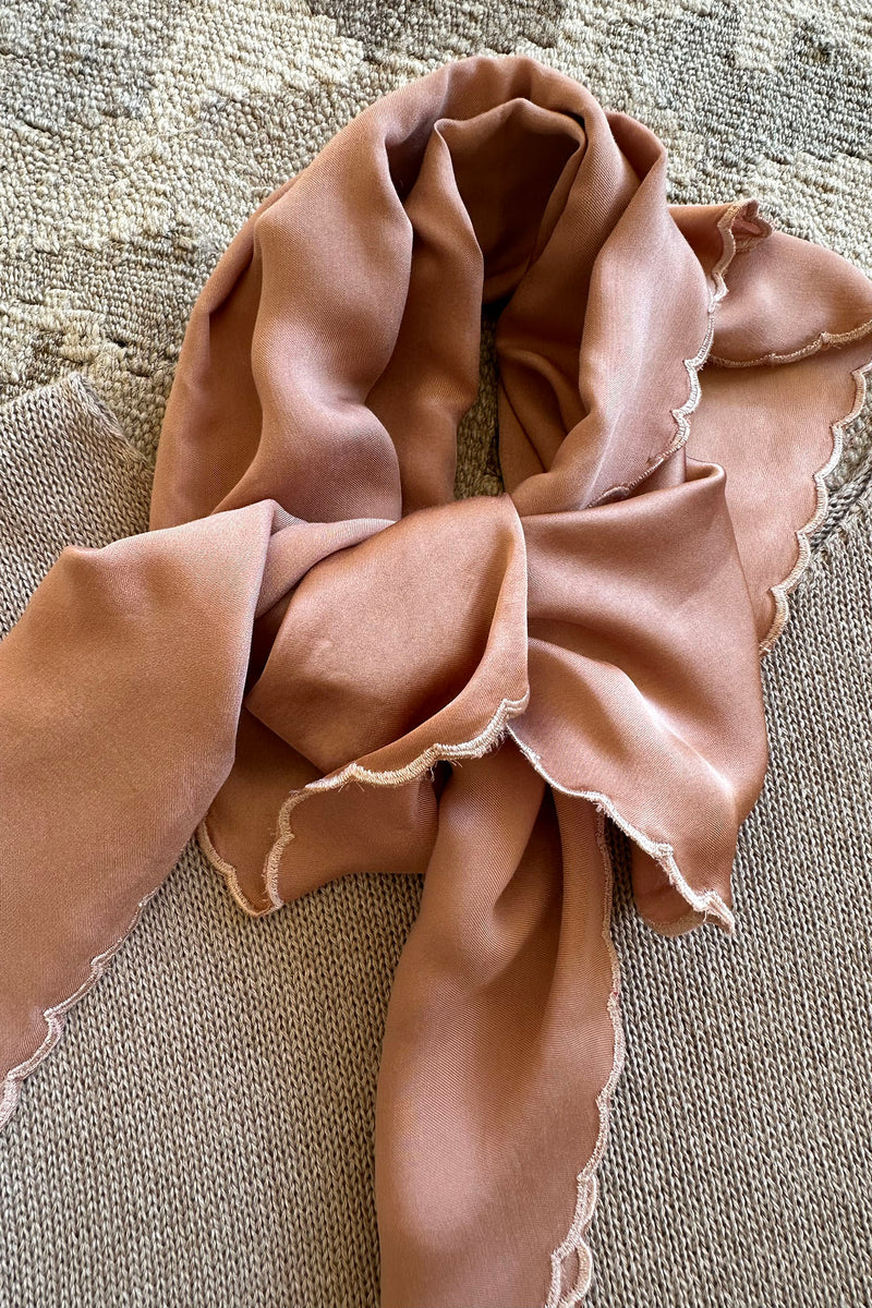 Pink satin scarf with lace trim on a knit top