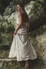 Woman wearing a pink sating halterneck top designed for comfort and movement through the body