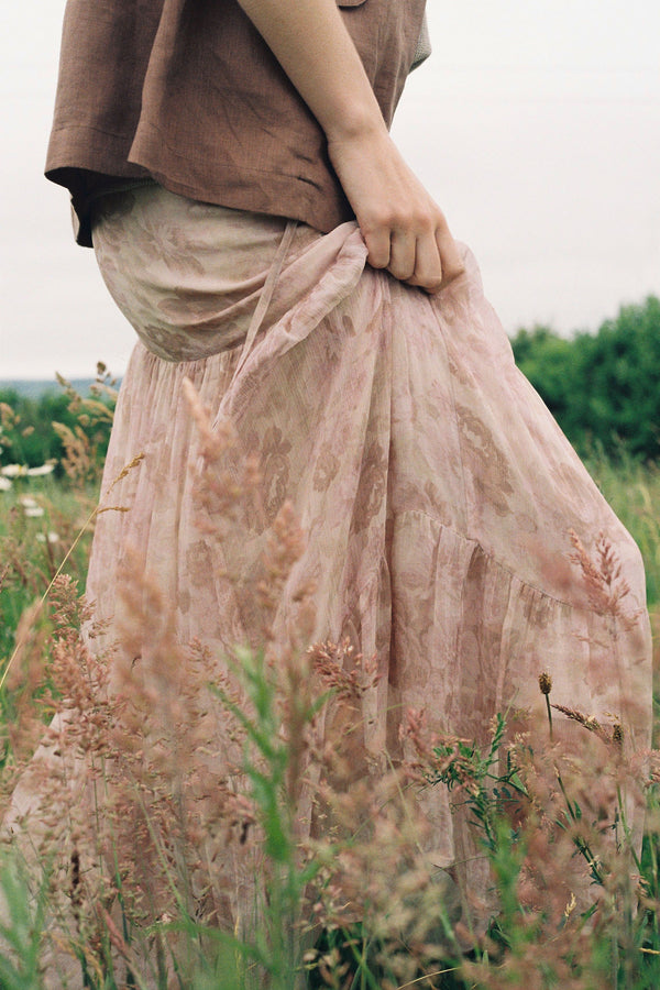 a woman wearing floral maxi skirt in the field