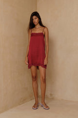 Satin slip mini dress in Merlot Red styled with relaxed sandals