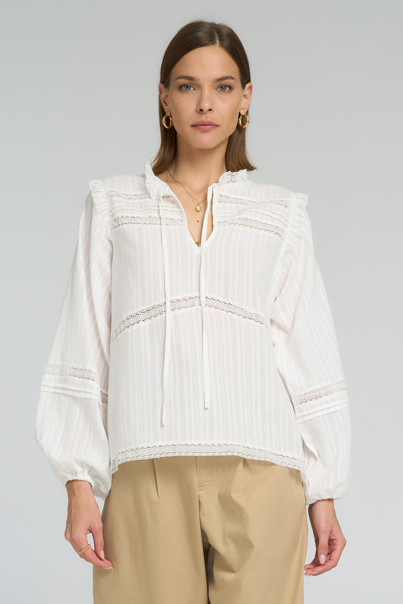 Romantic vintage-inspired cotton blouse with lace detailing and soft V-neckline