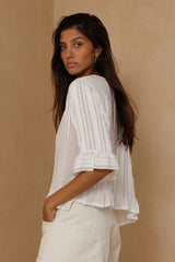 Vintage-inspired white blouse styled with relaxed denim 