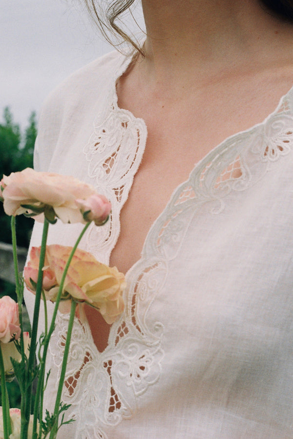 Close-up of a person wearing a lace garment holding flowers
