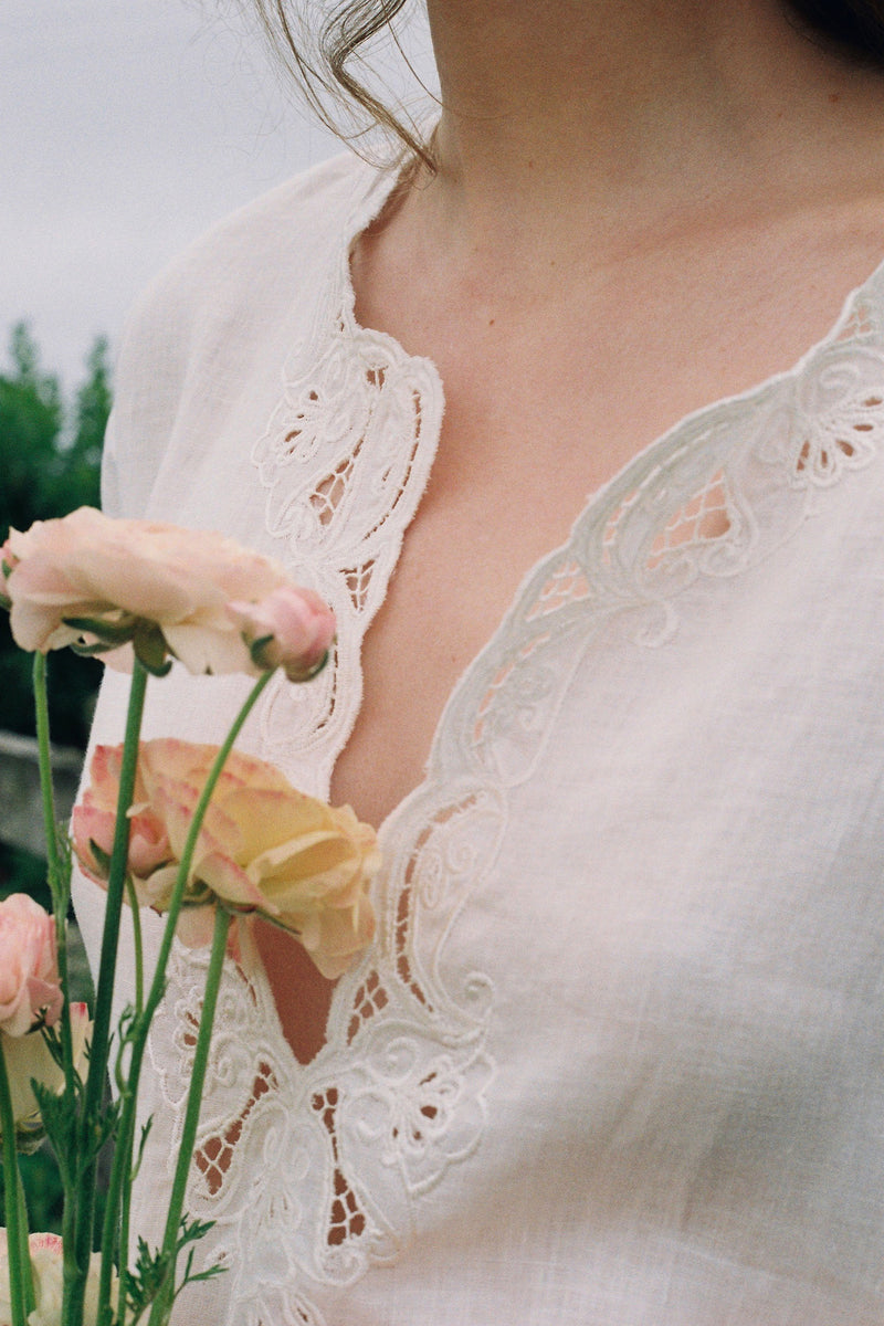 Close-up of a person wearing a lace garment holding flowers