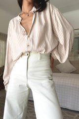 Woman wearing a striped shirt and white pants